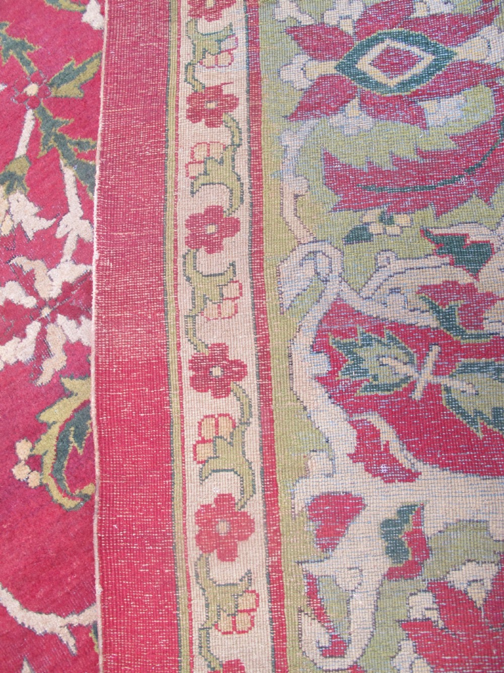A large hand-knotted wool Amritsar carpet featuring a crimson red field decorated with olive green, cream, and pink floral vine arabesques. View XI