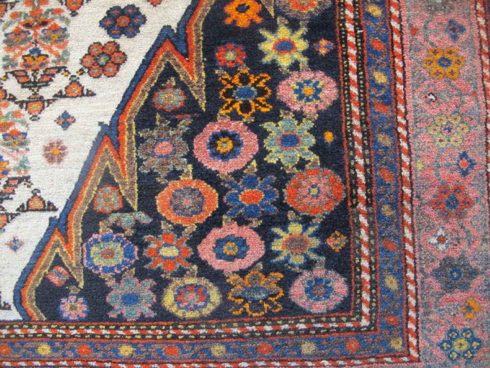 An antique hand-knotted Persian Melayir wool rug featuring an ivory central field with repeating geometric floral motifs, dark spandrels, and a terracotta border. View IV