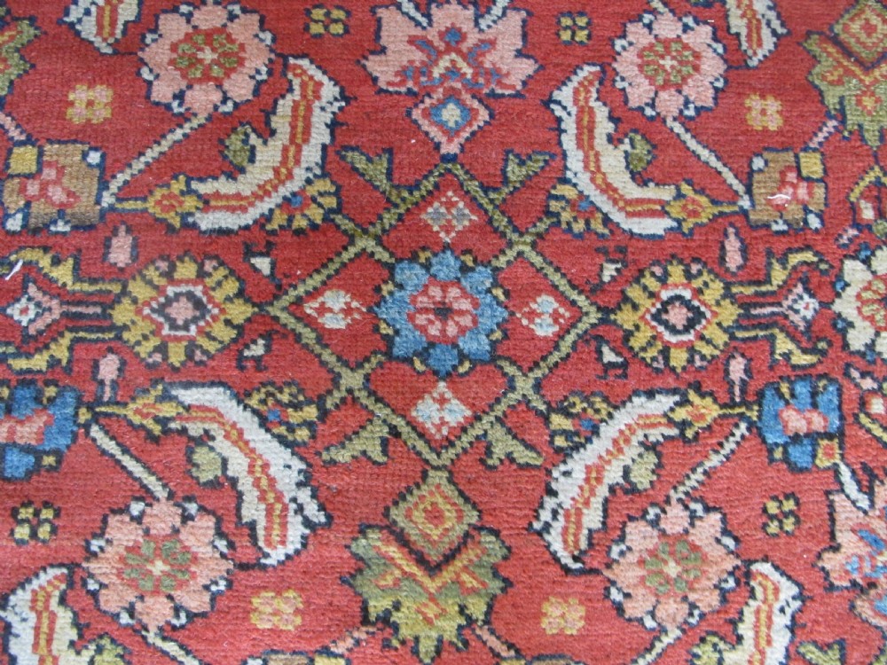 A large 19th-century antique Persian Mahal carpet featuring a terracotta red field with repeating floral lattice motifs and broad multi-tiered decorative borders. View III