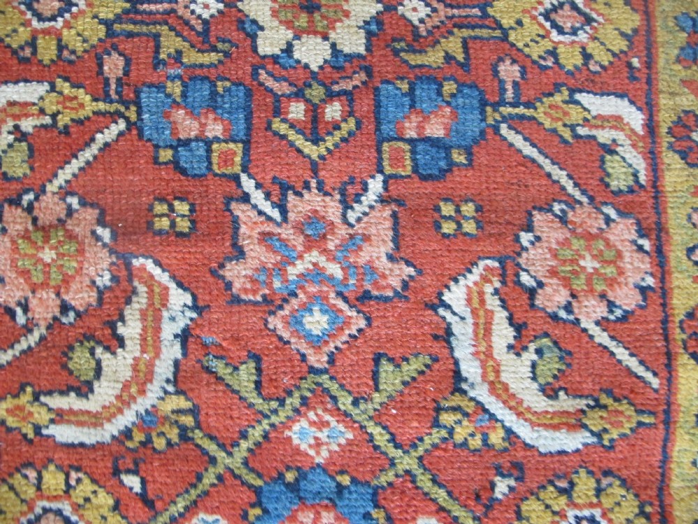 A large 19th-century antique Persian Mahal carpet featuring a terracotta red field with repeating floral lattice motifs and broad multi-tiered decorative borders. View IV