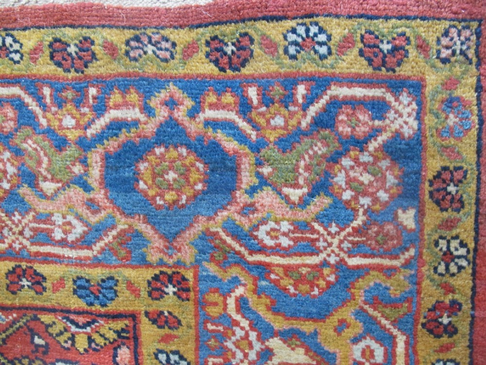 A large 19th-century antique Persian Mahal carpet featuring a terracotta red field with repeating floral lattice motifs and broad multi-tiered decorative borders. View V