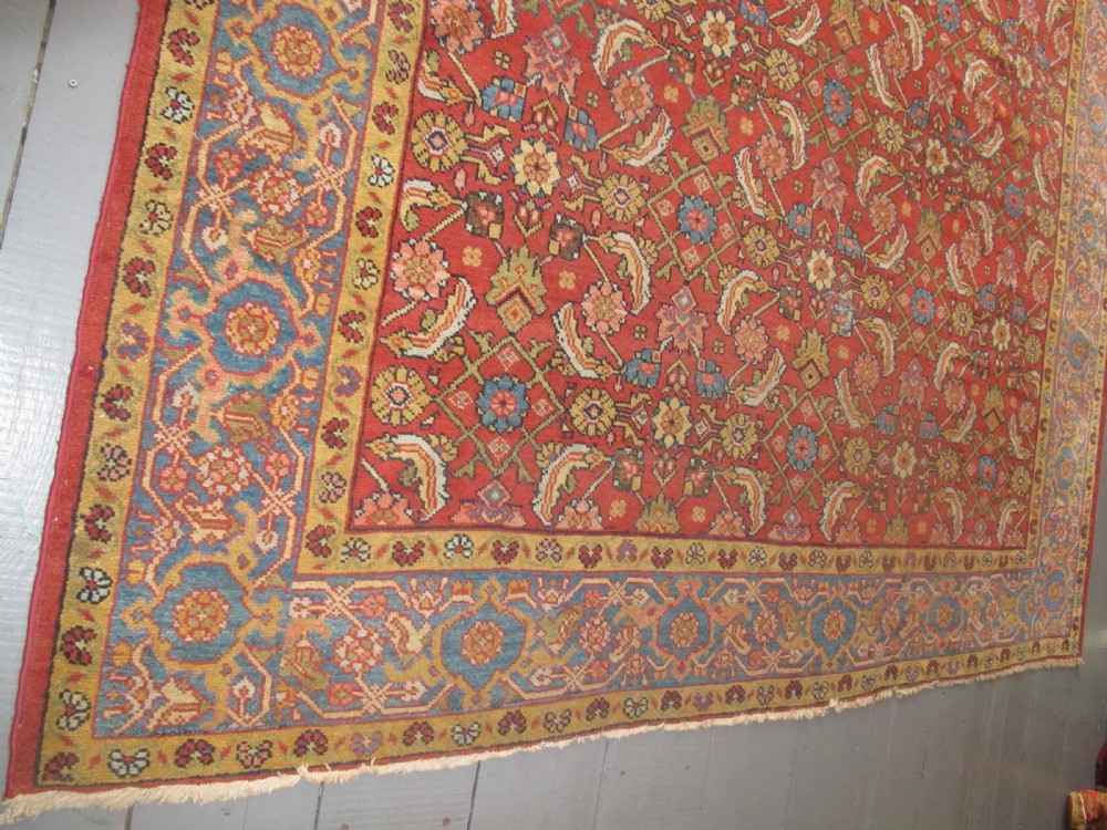A large 19th-century antique Persian Mahal carpet featuring a terracotta red field with repeating floral lattice motifs and broad multi-tiered decorative borders. View VII