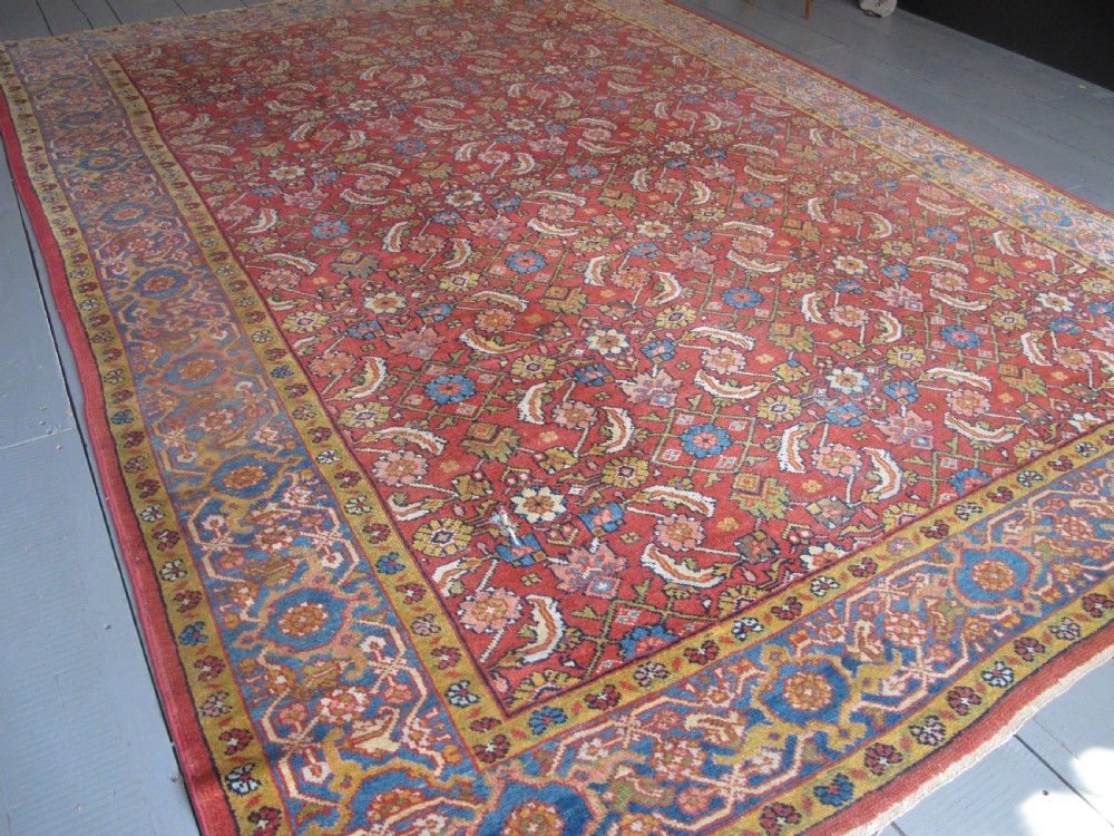 A large 19th-century antique Persian Mahal carpet featuring a terracotta red field with repeating floral lattice motifs and broad multi-tiered decorative borders. View VIII