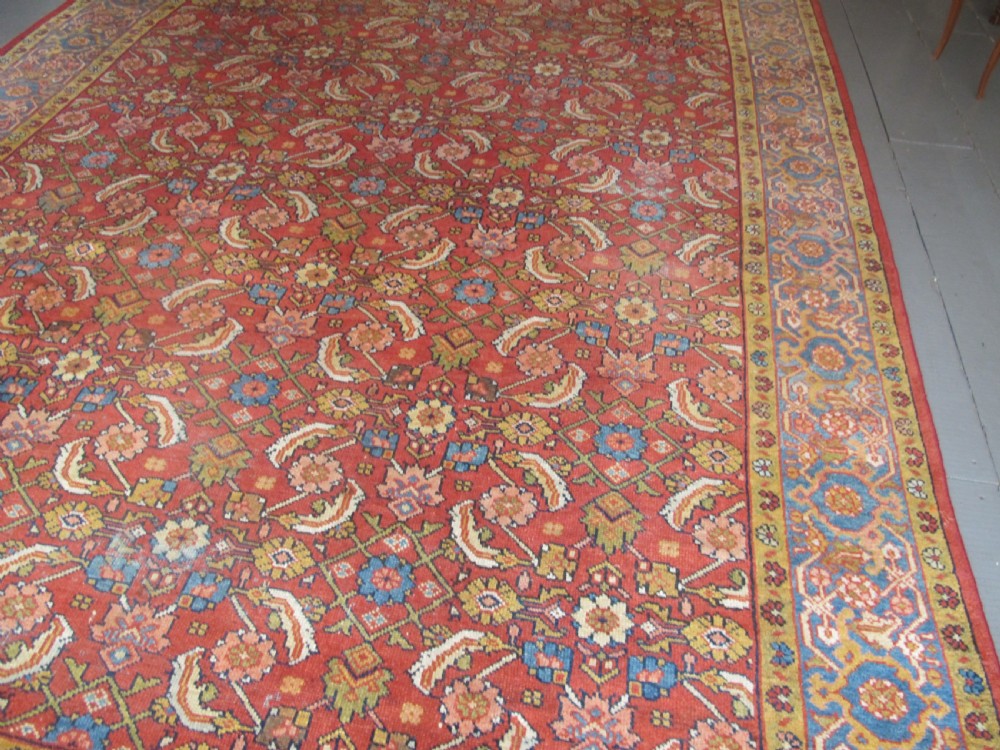 A large 19th-century antique Persian Mahal carpet featuring a terracotta red field with repeating floral lattice motifs and broad multi-tiered decorative borders. View IX