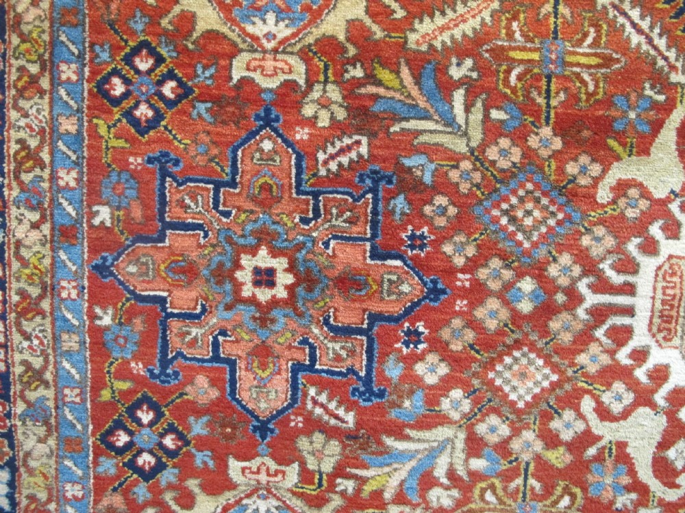 An antique late 19th-century Persian Karaja wool carpet featuring a terracotta red field filled with geometric medallions and surrounded by a detailed dark indigo border. View VIII