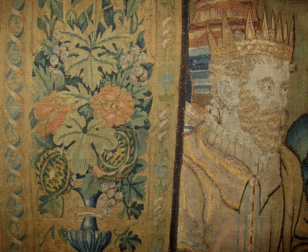 A large 16th-century Flemish Renaissance tapestry woven with figures in classical attire framed by an elaborate floral and fruit border. View V