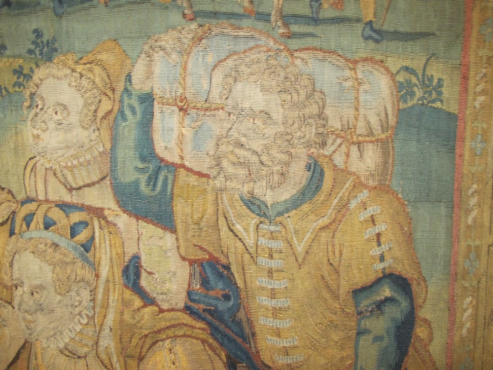 A large 16th-century Flemish Renaissance tapestry woven with figures in classical attire framed by an elaborate floral and fruit border. View IX