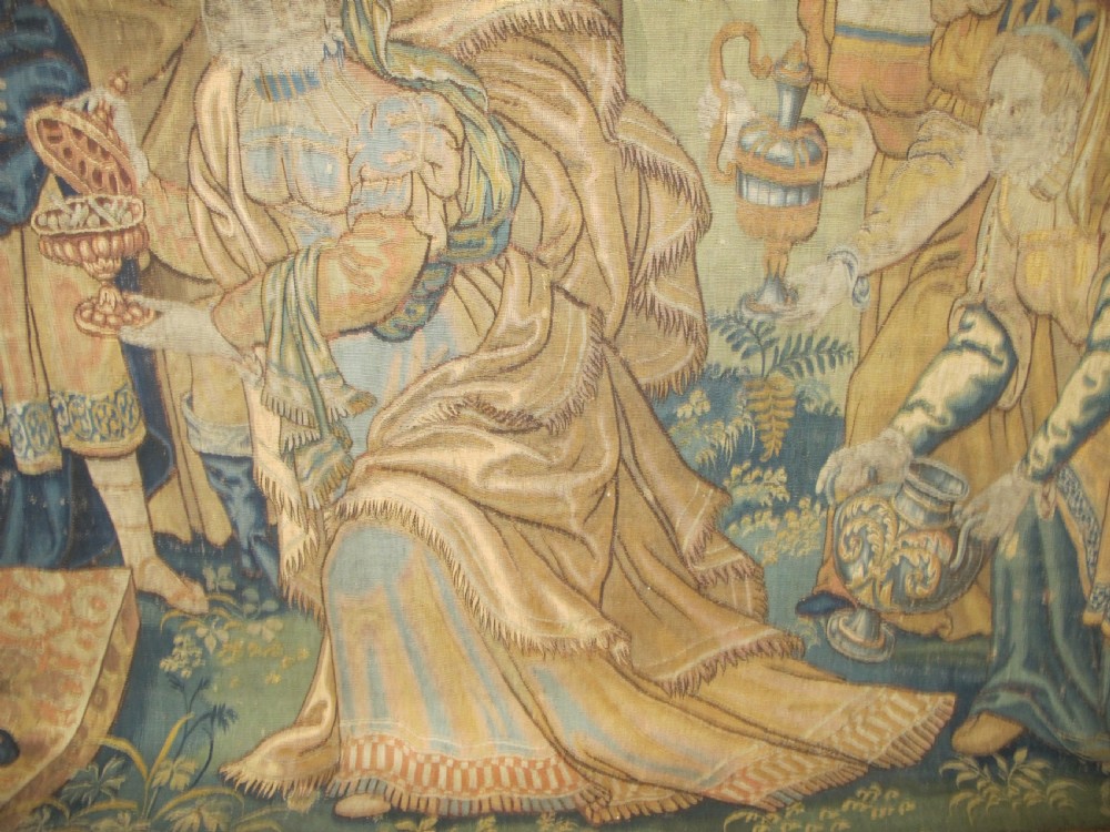 A large 16th-century Flemish Renaissance tapestry woven with figures in classical attire framed by an elaborate floral and fruit border. View X