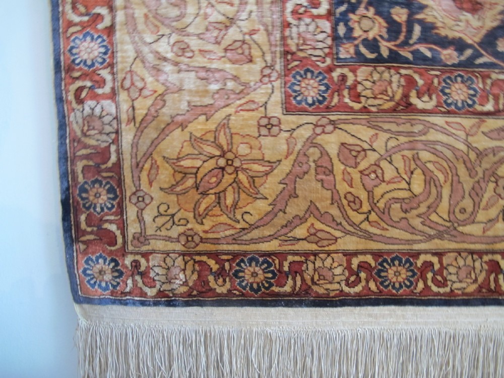 A mid-20th-century Turkish silk rug featuring a dark navy mihrab arch filled with floral motifs, surrounded by an ochre border with calligraphic script and bird illustrations. View III