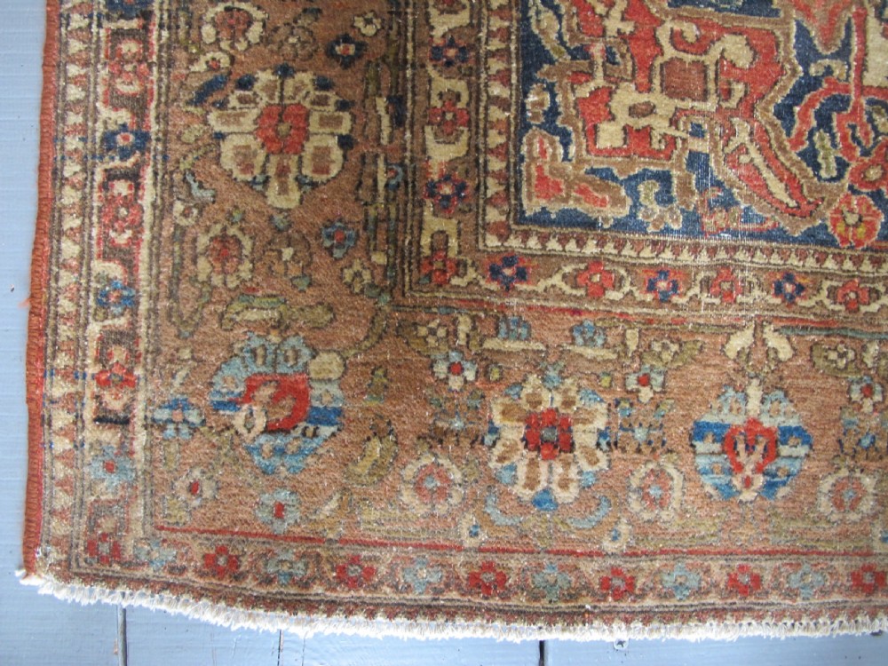 An antique hand-knotted Persian Isfahan area rug featuring an intricate dark blue and terracotta central medallion on an ivory floral field with decorative patterned borders. View VII