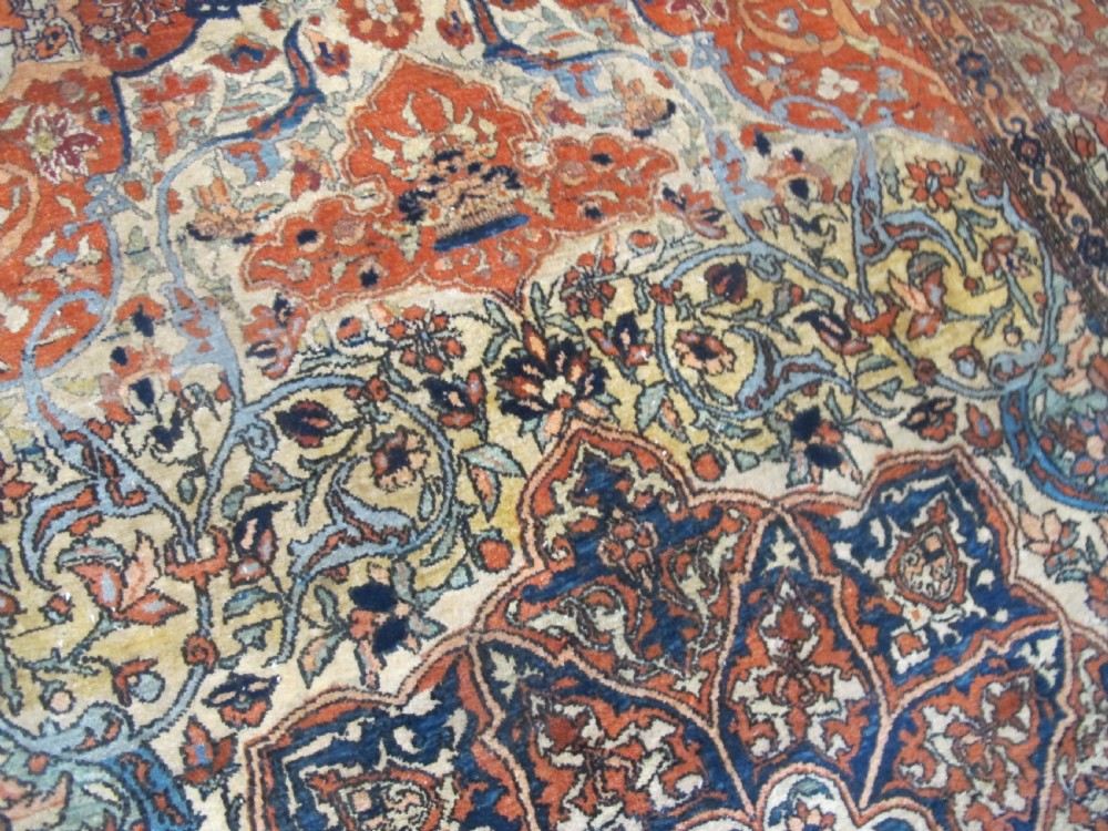 An antique hand-knotted Persian Isfahan rug featuring a central floral medallion surrounded by arabesque scrollwork and detailed multi-banded borders in terracotta red, navy blue, and cream. View VIII