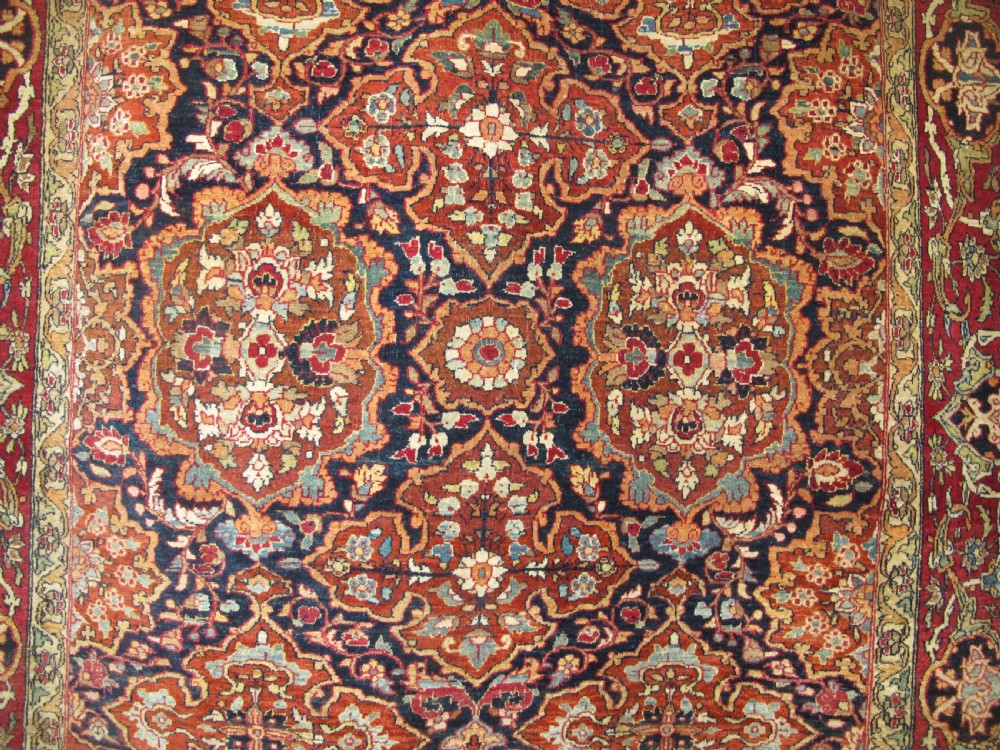 An antique hand-knotted Persian Isfahan rug featuring a dense floral lattice pattern in crimson red, navy blue, and cream with a detailed border. View XIII