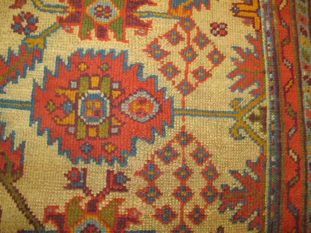 A large hand-knotted wool Oushak carpet featuring a golden-yellow field with geometric medallion motifs bordered by wide terracotta and orange patterned bands. View VIII