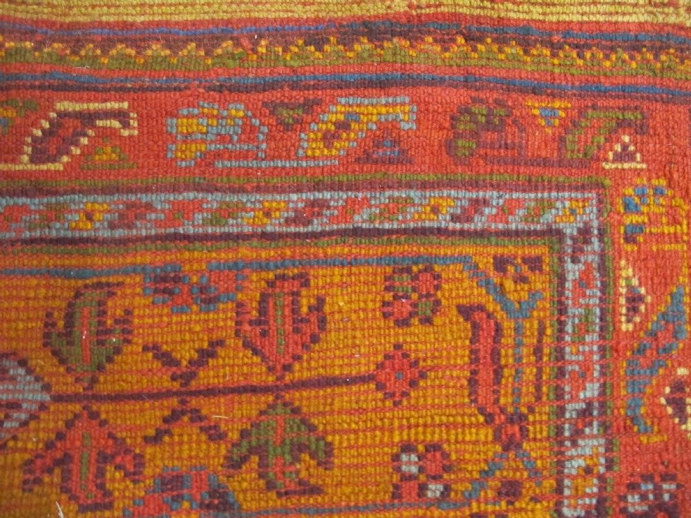 A large hand-knotted wool Oushak carpet featuring a golden-yellow field with geometric medallion motifs bordered by wide terracotta and orange patterned bands. View XIII