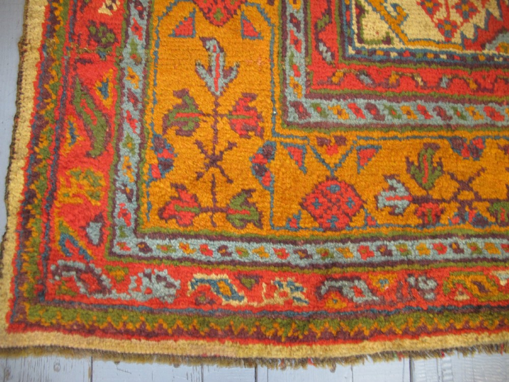 A large hand-knotted wool Oushak carpet featuring a golden-yellow field with geometric medallion motifs bordered by wide terracotta and orange patterned bands. View XIV