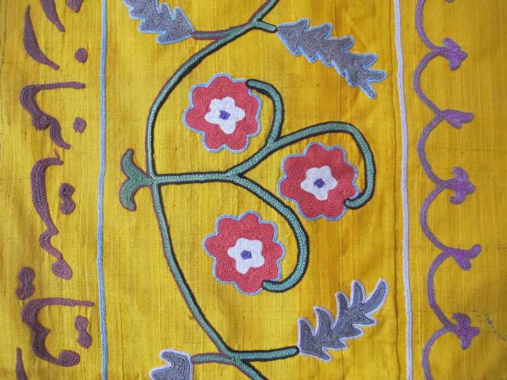 An early 20th-century yellow silk textile from Uzbekistan featuring hand-embroidered floral motifs, a central arch design, and calligraphic borders. View VI