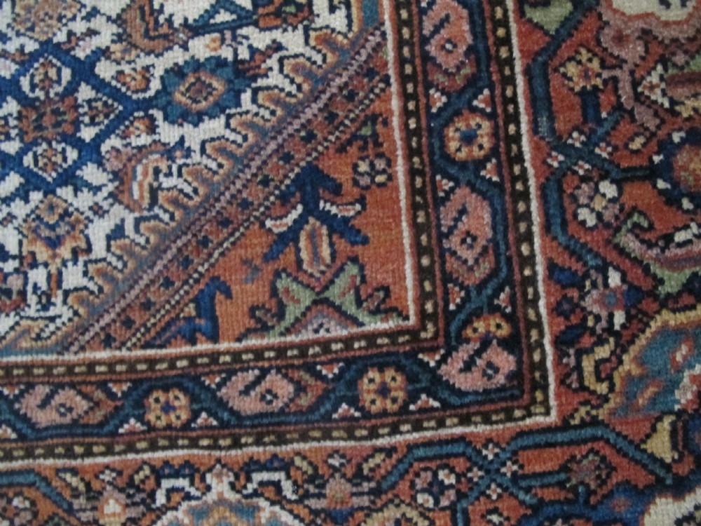 A rectangular antique Persian Fereghan rug with a detailed cream, terracotta, and navy Herati pattern bordered by intricate geometric bands. View VIII