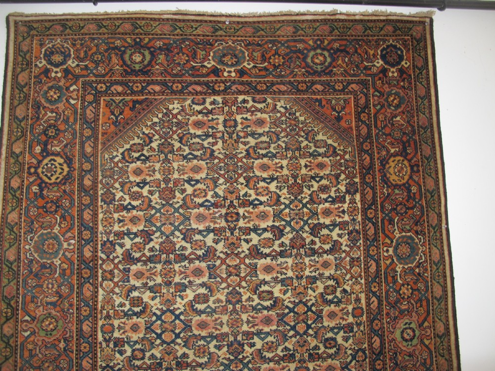 A rectangular antique Persian Fereghan rug with a detailed cream, terracotta, and navy Herati pattern bordered by intricate geometric bands. View IX