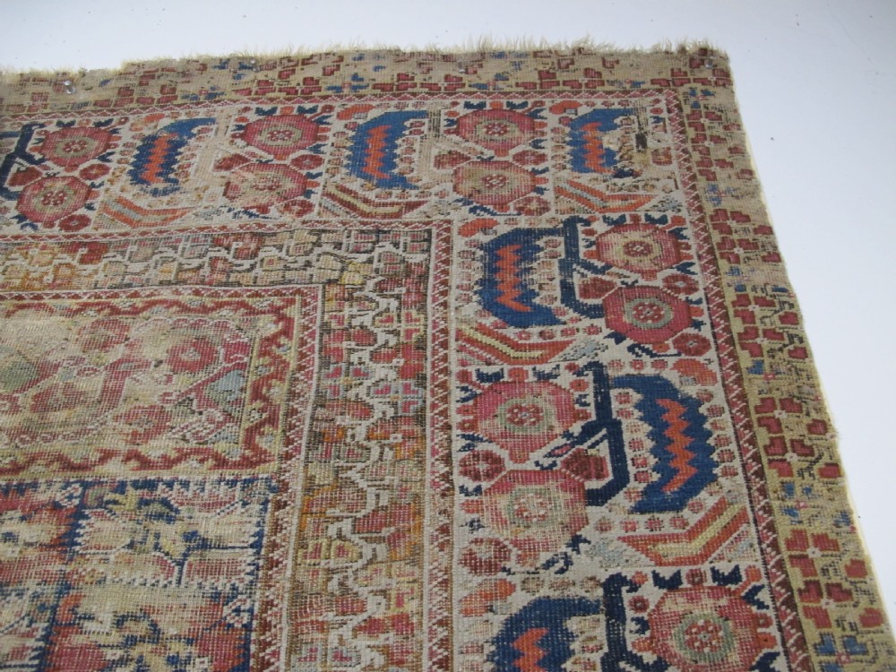 An 18th-century hand-knotted Ghiordes prayer rug featuring a central pale green mihrab niche framed by intricate floral borders in red, blue, and beige. View VI