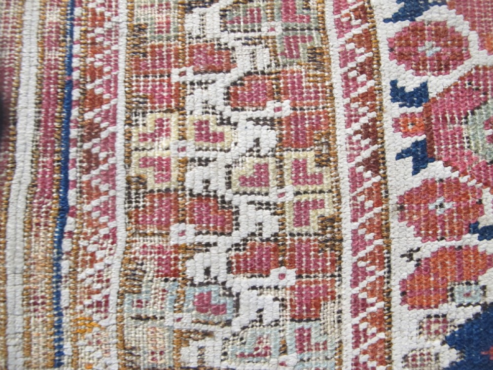 An 18th-century hand-knotted Ghiordes prayer rug featuring a central pale green mihrab niche framed by intricate floral borders in red, blue, and beige. View VII