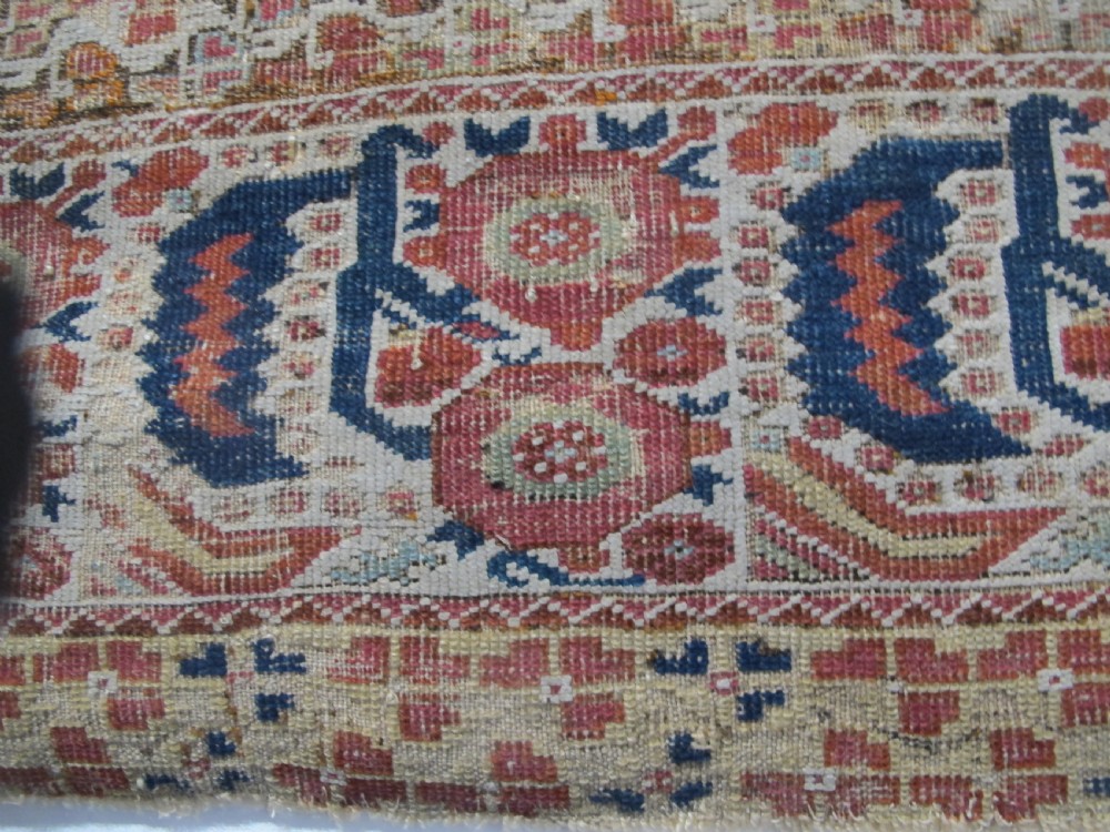 An 18th-century hand-knotted Ghiordes prayer rug featuring a central pale green mihrab niche framed by intricate floral borders in red, blue, and beige. View VIII