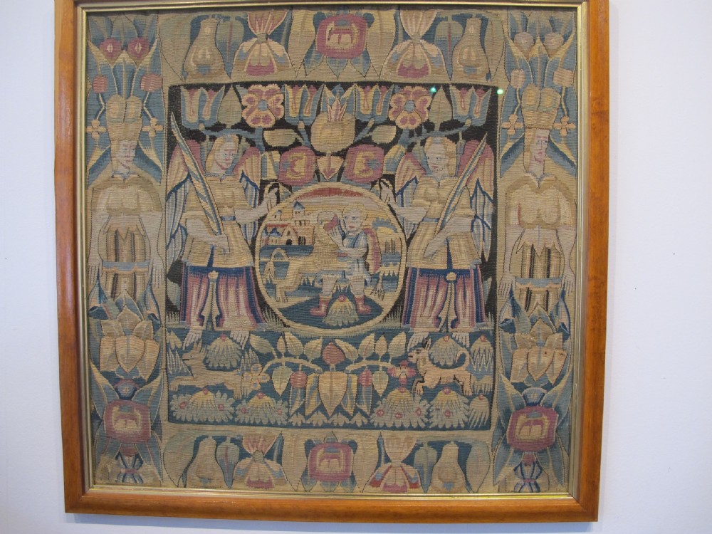 A pair of square 17th-century North German tapestry panels featuring allegorical figures and floral borders, presented in wooden frames. View II