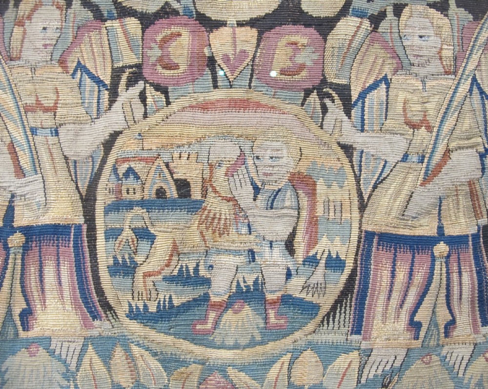 A pair of square 17th-century North German tapestry panels featuring allegorical figures and floral borders, presented in wooden frames. View IV