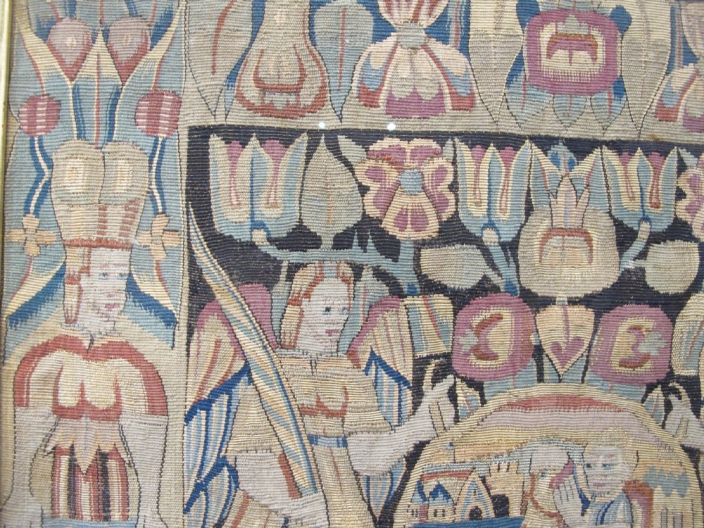 A pair of square 17th-century North German tapestry panels featuring allegorical figures and floral borders, presented in wooden frames. View V