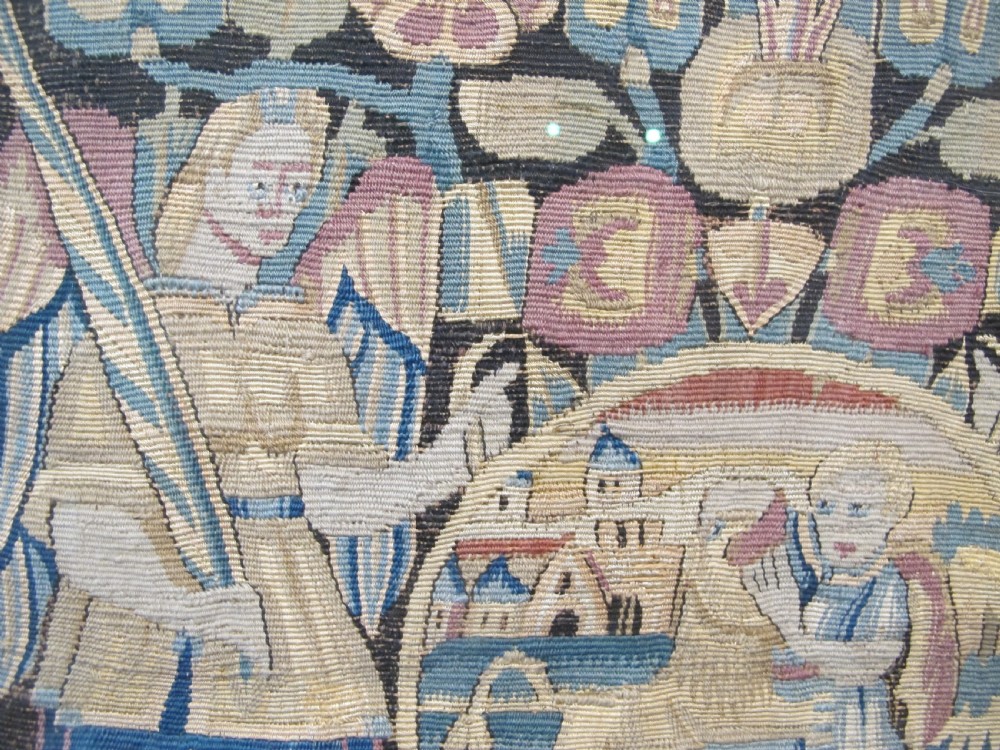 A pair of square 17th-century North German tapestry panels featuring allegorical figures and floral borders, presented in wooden frames. View IX