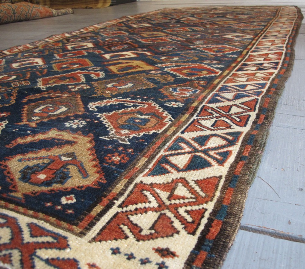 An antique late 19th-century North-West Persian hand-knotted wool runner rug featuring repeating geometric hook motifs on a dark blue field framed by geometric borders. View II