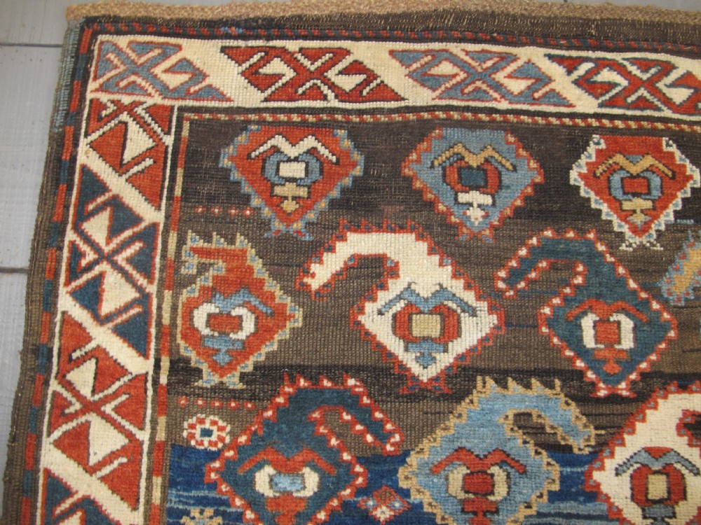 An antique late 19th-century North-West Persian hand-knotted wool runner rug featuring repeating geometric hook motifs on a dark blue field framed by geometric borders. View IV
