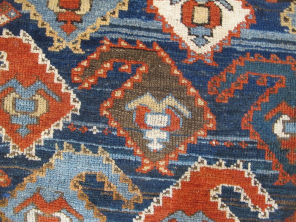 An antique late 19th-century North-West Persian hand-knotted wool runner rug featuring repeating geometric hook motifs on a dark blue field framed by geometric borders. View VII