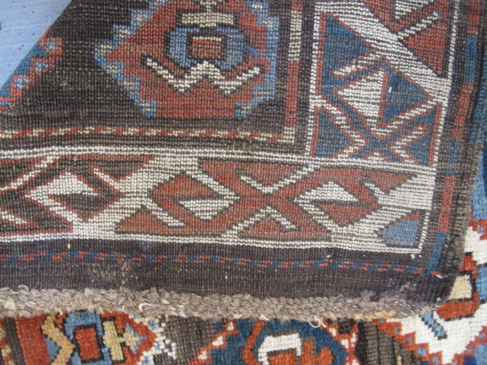 An antique late 19th-century North-West Persian hand-knotted wool runner rug featuring repeating geometric hook motifs on a dark blue field framed by geometric borders. View IX