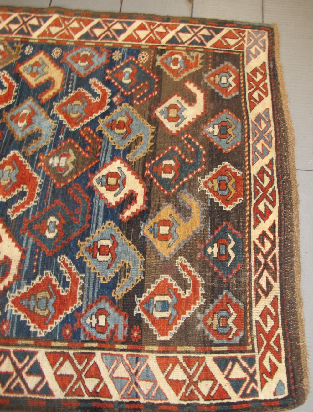 An antique late 19th-century North-West Persian hand-knotted wool runner rug featuring repeating geometric hook motifs on a dark blue field framed by geometric borders. View X