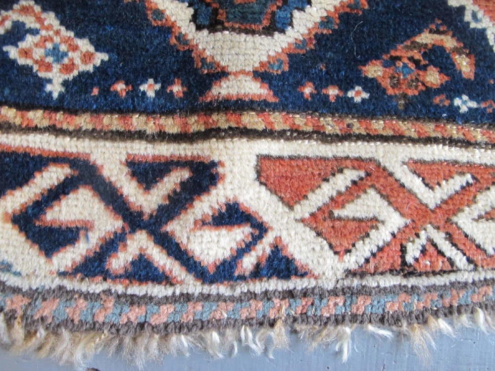 An antique late 19th-century North-West Persian hand-knotted wool runner rug featuring repeating geometric hook motifs on a dark blue field framed by geometric borders. View XI