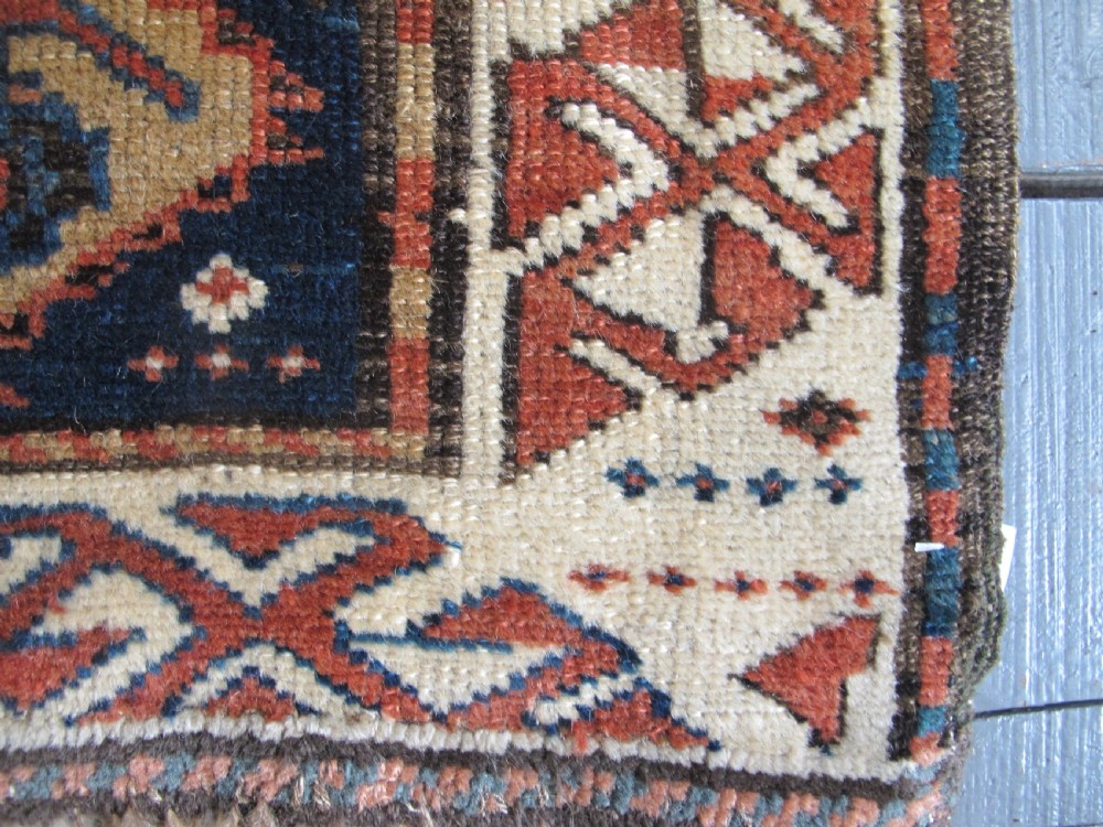 An antique late 19th-century North-West Persian hand-knotted wool runner rug featuring repeating geometric hook motifs on a dark blue field framed by geometric borders. View XII