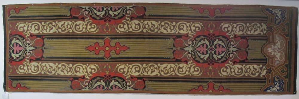A long horizontal European wool tapestry panel featuring ornate scrolling foliage, geometric motifs, and metallic thread detailing in tones of red, olive, and beige.