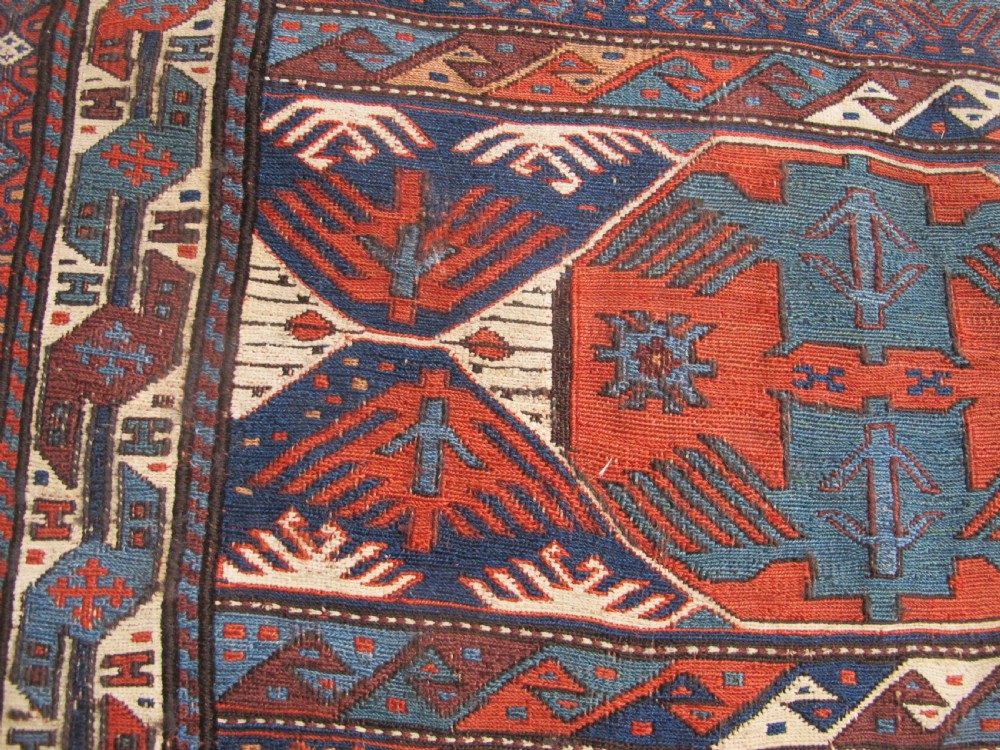 A pair of antique Caucasian Shahsavan soumac woven bags featuring geometric medallions in terracotta red, navy blue, and cream wool with decorative loops along the top edge. View XI