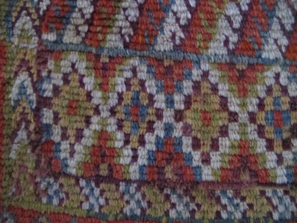 An antique rectangular Moroccan Glaoui rug featuring geometric diamond and chevron patterns in terracotta red, ochre, cream, and charcoal tones. View VII