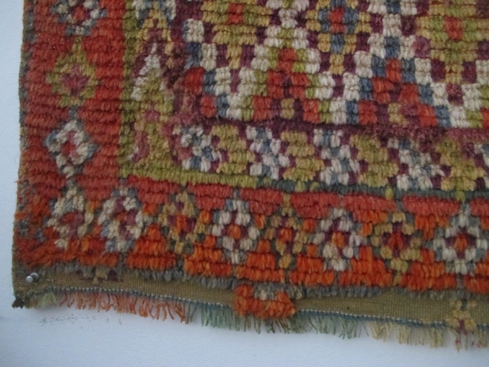 An antique rectangular Moroccan Glaoui rug featuring geometric diamond and chevron patterns in terracotta red, ochre, cream, and charcoal tones. View XI