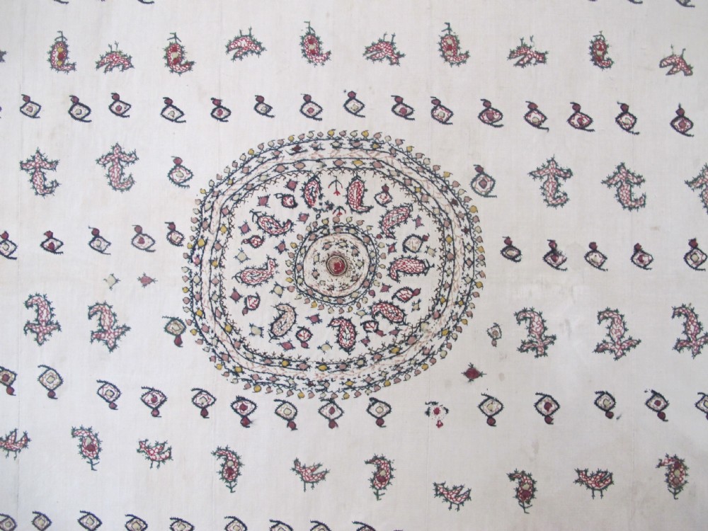 A square cream silk embroidered textile with a central circular medallion surrounded by repeating rows of small boteh motifs and a patterned border. View II