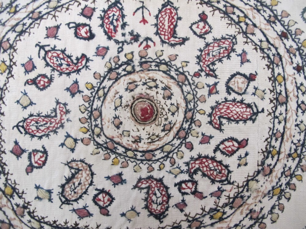 A square cream silk embroidered textile with a central circular medallion surrounded by repeating rows of small boteh motifs and a patterned border. View III