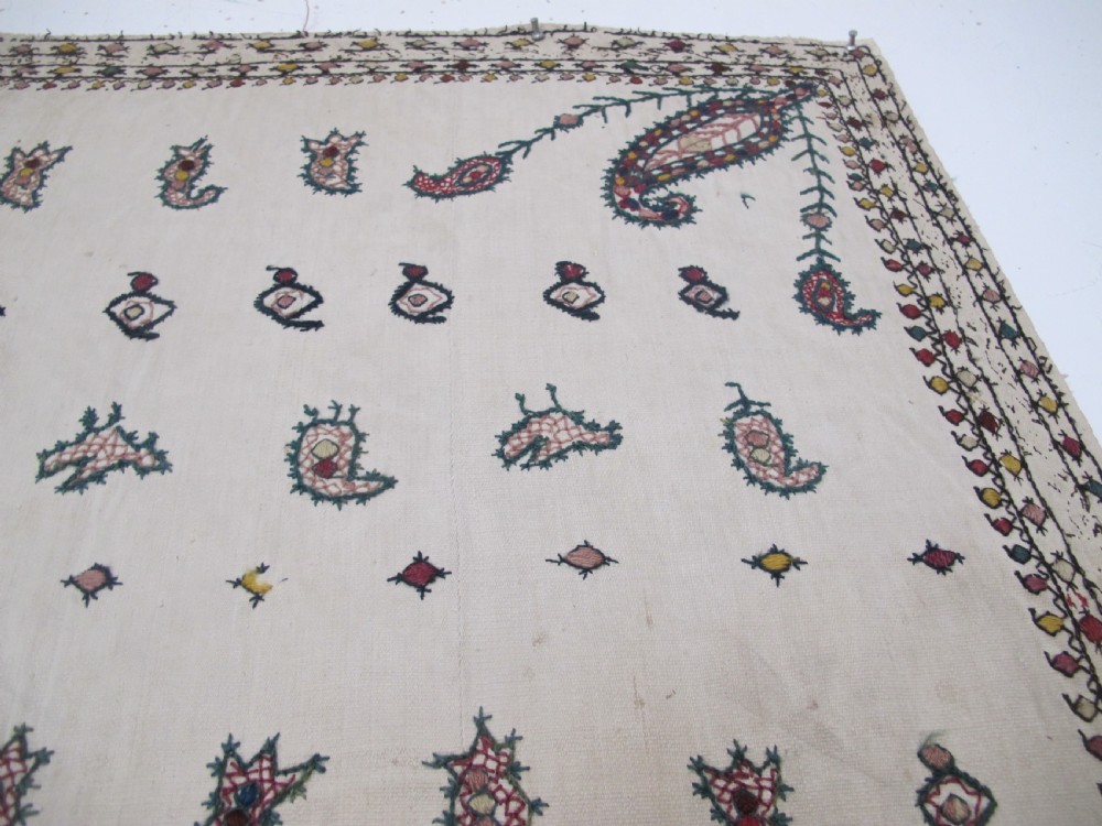 A square cream silk embroidered textile with a central circular medallion surrounded by repeating rows of small boteh motifs and a patterned border. View VIII