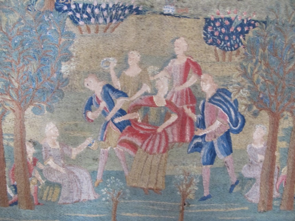 An antique square silk needlework panel displaying figurative pastoral scenes inside a wide floral border. View IV