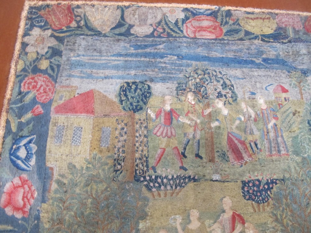 An antique square silk needlework panel displaying figurative pastoral scenes inside a wide floral border. View XI