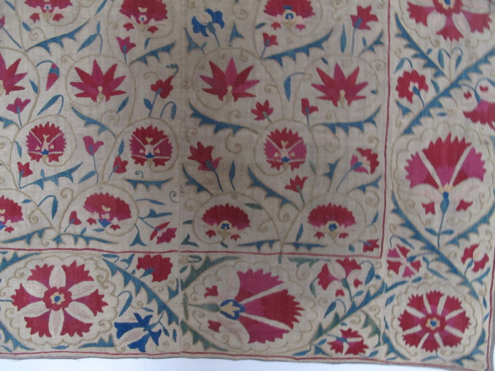 A rectangular antique silk-embroidered Suzani textile featuring crimson floral motifs and scrolling leaf borders on a beige cotton ground. View VIII