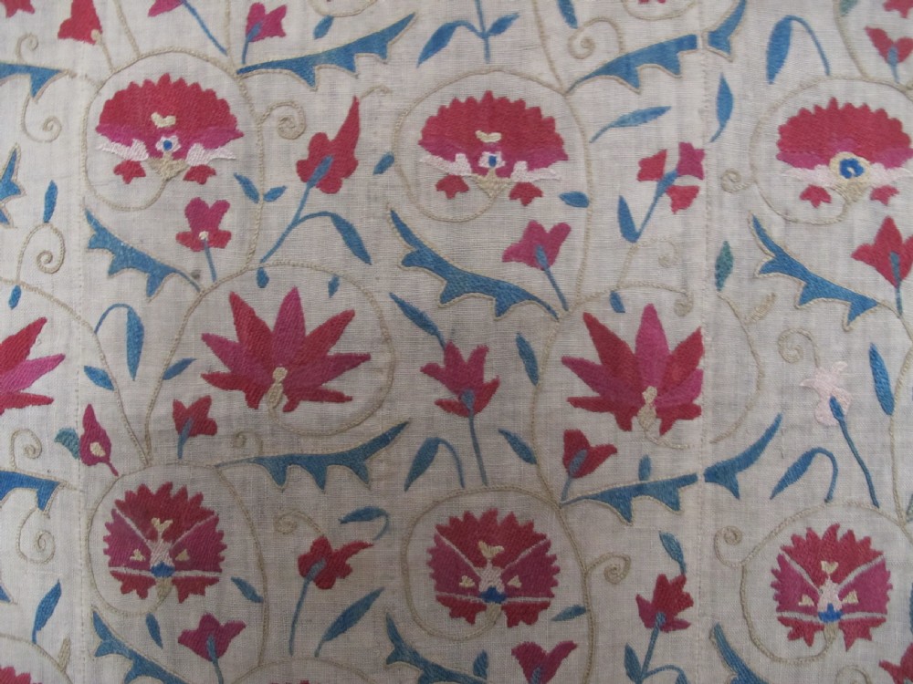 A rectangular antique silk-embroidered Suzani textile featuring crimson floral motifs and scrolling leaf borders on a beige cotton ground. View IX