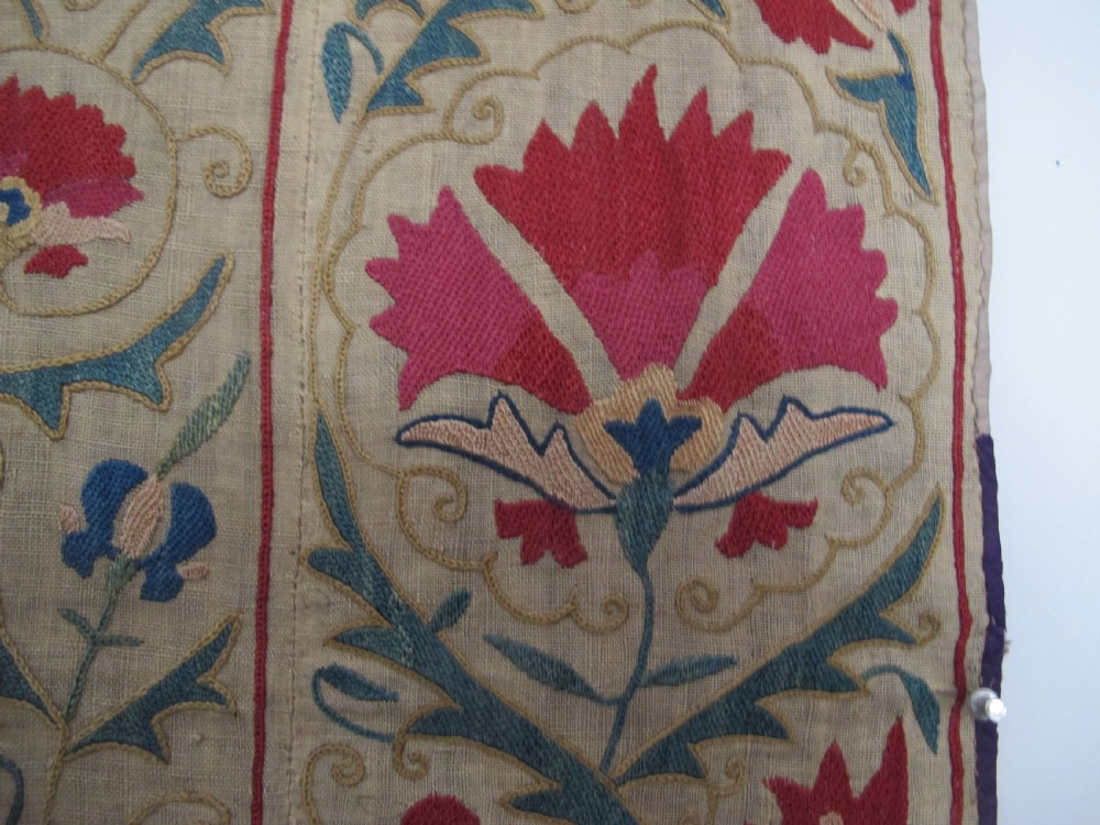 A rectangular antique silk-embroidered Suzani textile featuring crimson floral motifs and scrolling leaf borders on a beige cotton ground. View XIII