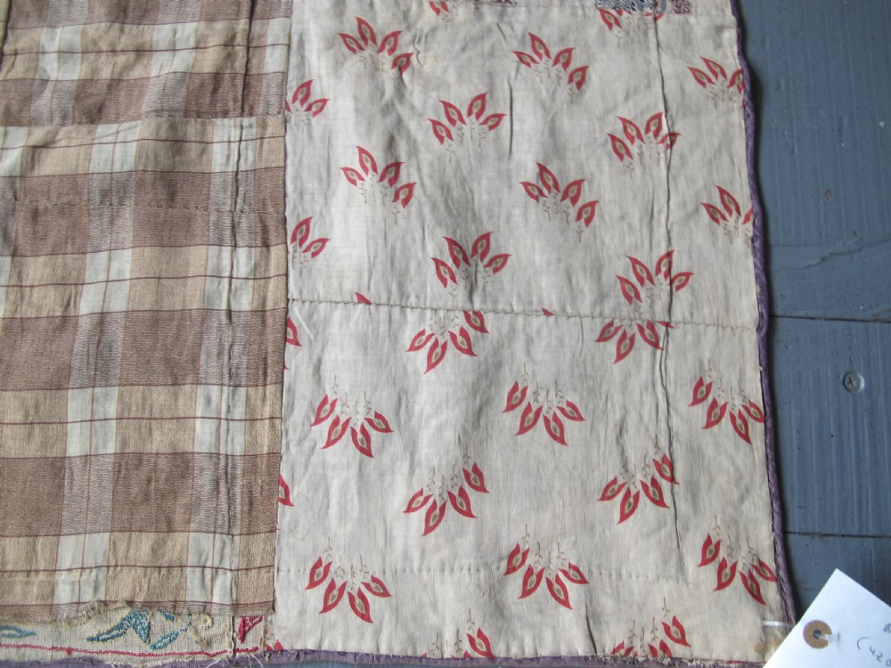 A rectangular antique silk-embroidered Suzani textile featuring crimson floral motifs and scrolling leaf borders on a beige cotton ground. View XV
