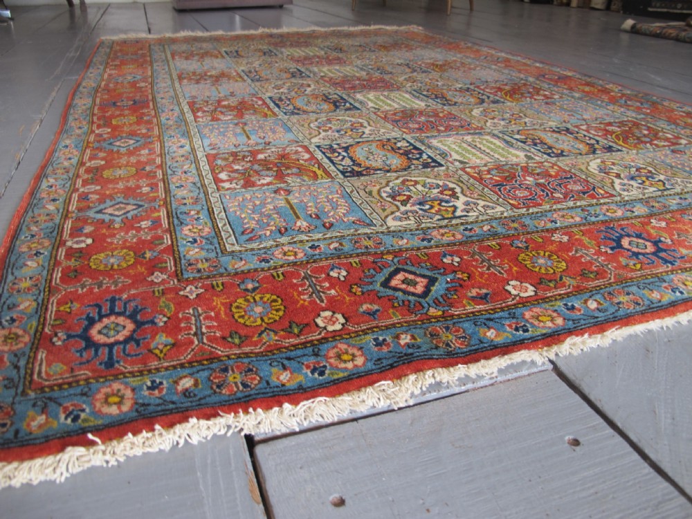 A rectangular hand-knotted Persian Qum rug featuring a central field of grid compartments filled with botanical and cypress motifs framed by a red border. View II